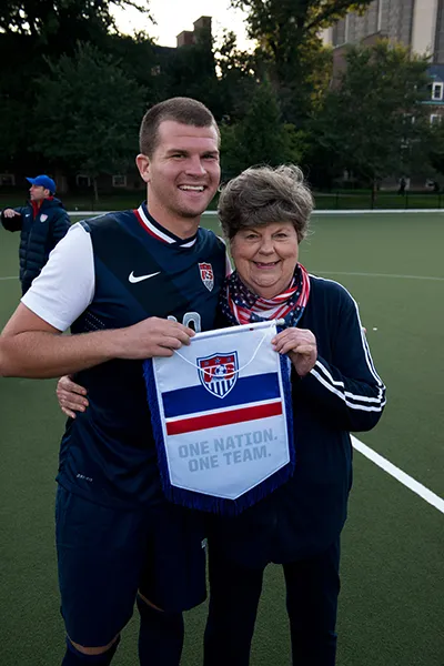 A young man and his Grandmother holding a sports flag