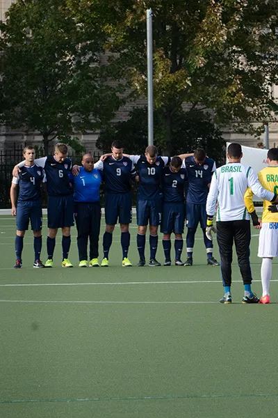 A soccer team lined up shoulder to shoulder, facing another team