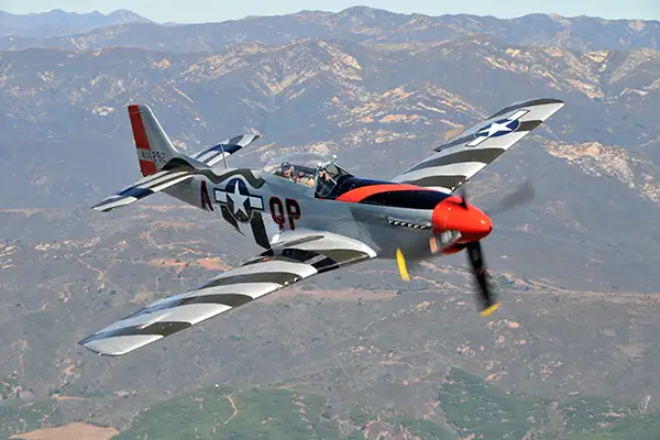 A WWII airplane soars through the air