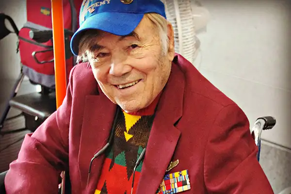 An older gentleman smiles at the camera
