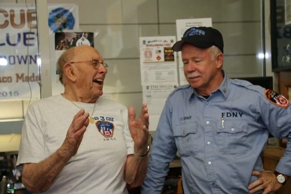 An older man chats with a New York firefighter