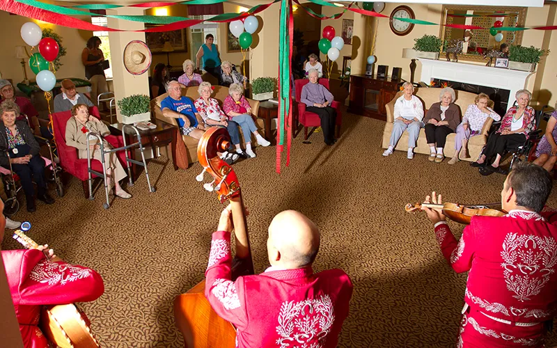 A Mariachi band surrounded by people in a community room