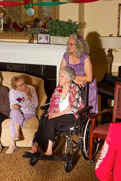 Three older women watch a house concert