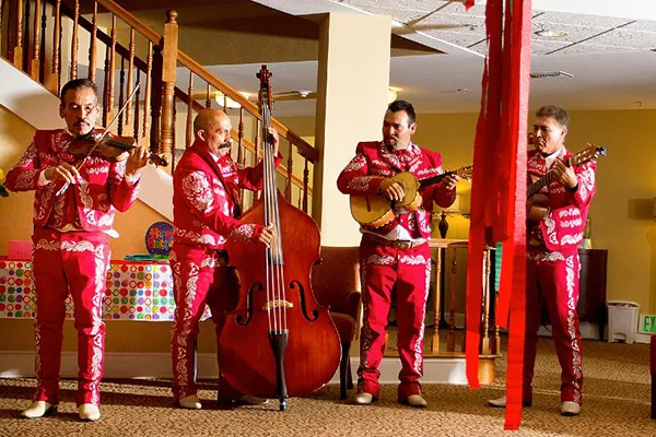 A mariachi band wearing bright red suits