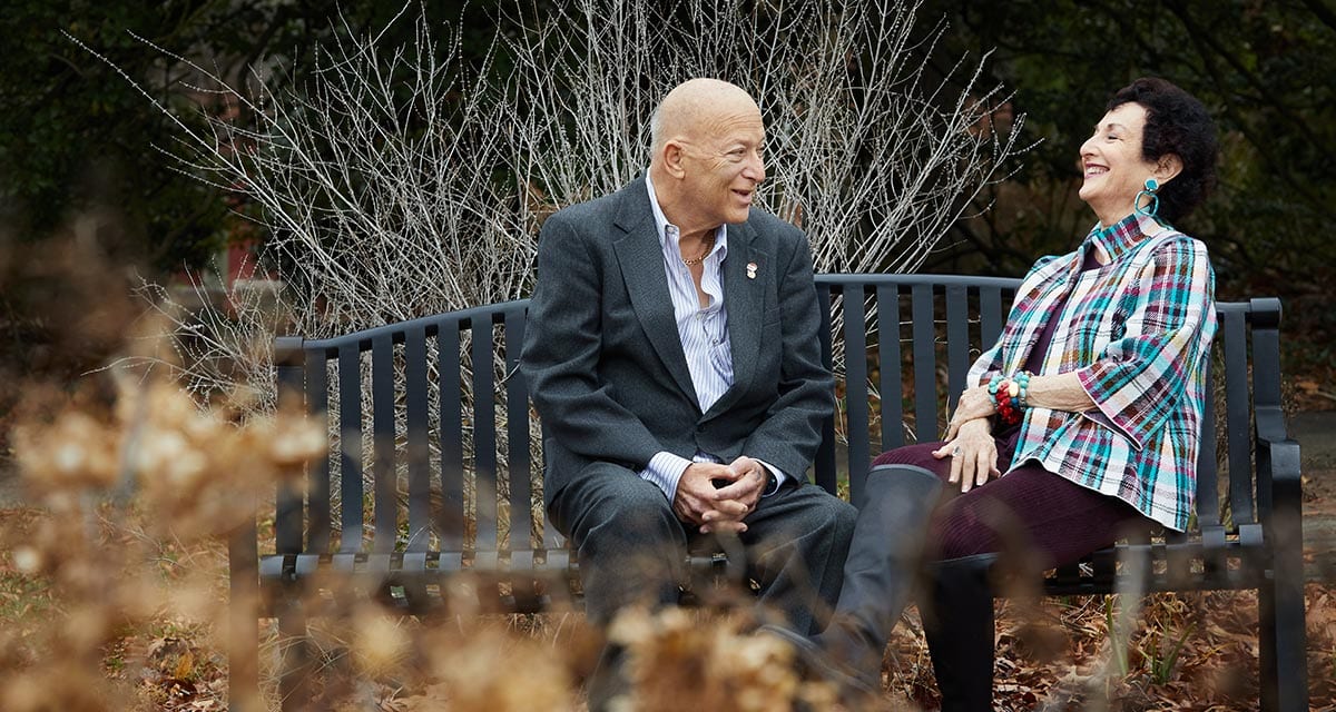 Harold and sister laughing together on park bench