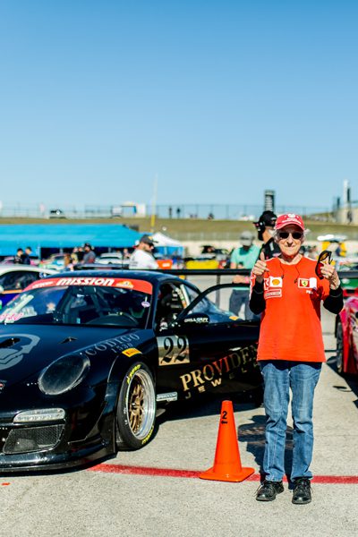 Wish recipient Judi stands in front of race cars