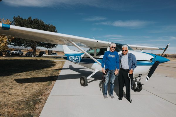 Heinz and Gunar stand in front of Cessna airplane and smile