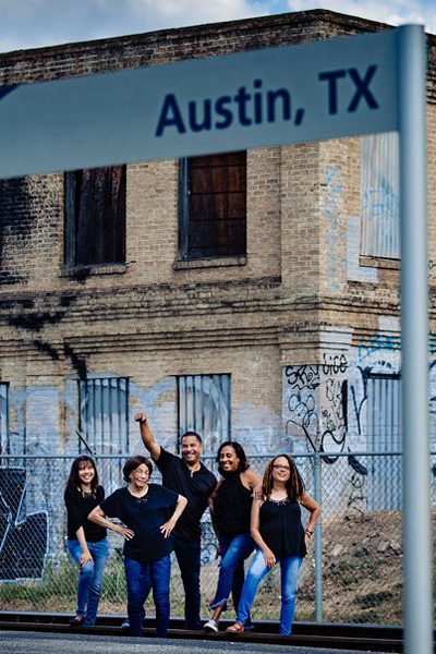 Louvenia's family poses under the Amtrak sign for Austin train station