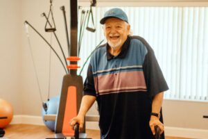 Wish recipient John smiling broadly by exercise equipment