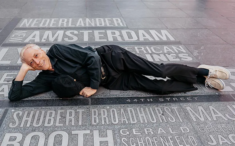 A man lays on the sidewalk on Shubert Broadhurst on Broadway in New York City