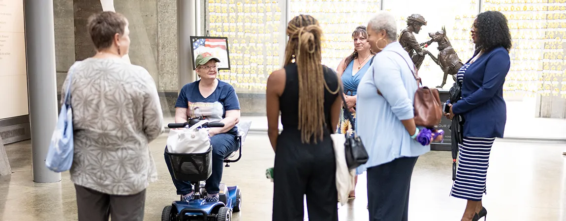 A woman in a motorized wheelchair is surrounded by other women.