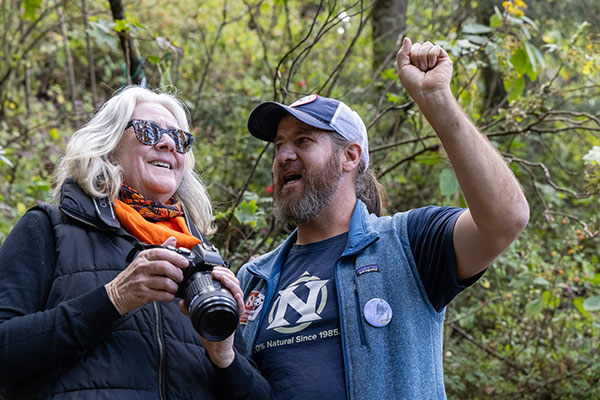 A woman with a camera receives instruction from a tour guide.
