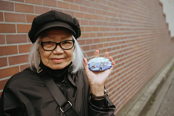 A Filipino woman holds a souvenir from a whale watching trip.