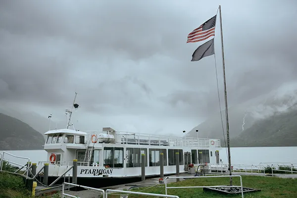 A whale watching tour boat sits along a shoreline.