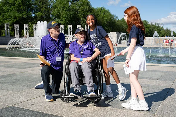 Two elementary students greet two Vietnam War veterans.