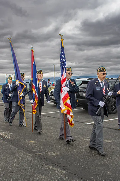 Military veterans march in a flag ceremony.