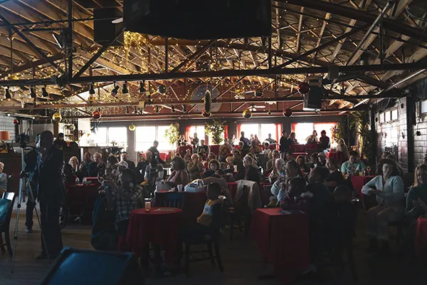 A small audience sits in a live performance venue.