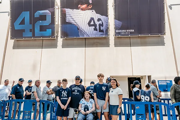 A family stands in front of a sign for a New York Yankees player.