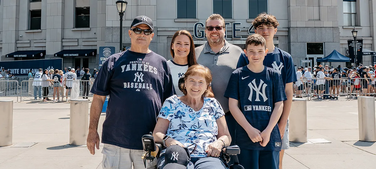 A woman in a wheelchair sits with her family outside Yankee Stadium.