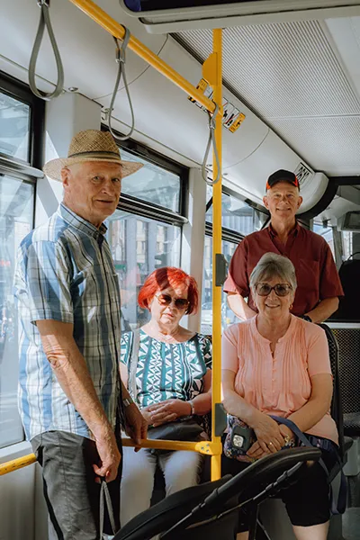 Four older individuals ride public transportation.