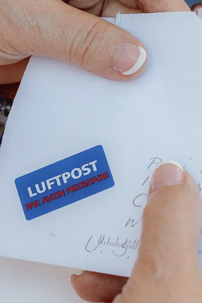 A woman holds a letter with a German postmark.