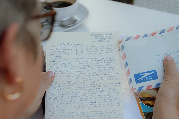 A woman reads a hand-written letter.