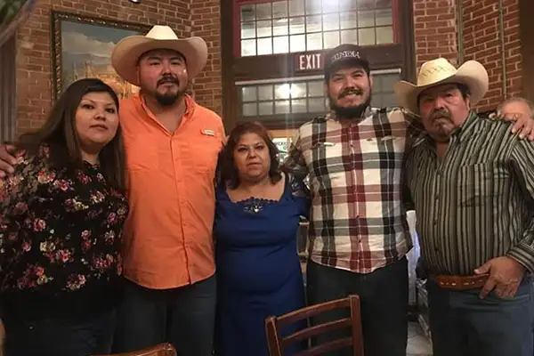A Mexican family stands inside a restaurant.