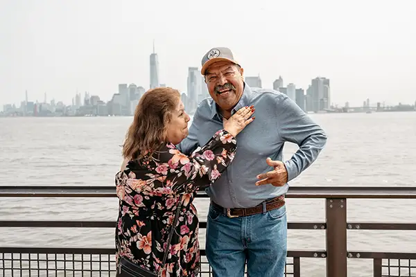 An woman touches of the shirt of a man while he laughs.