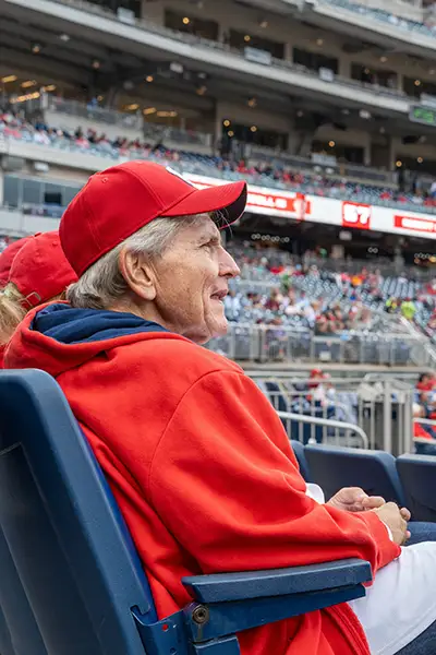 A man in a baseball cap sits in a stadium.