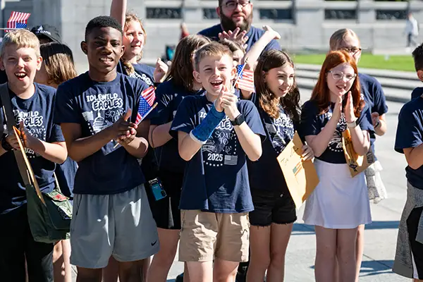Children holding flags and clapping