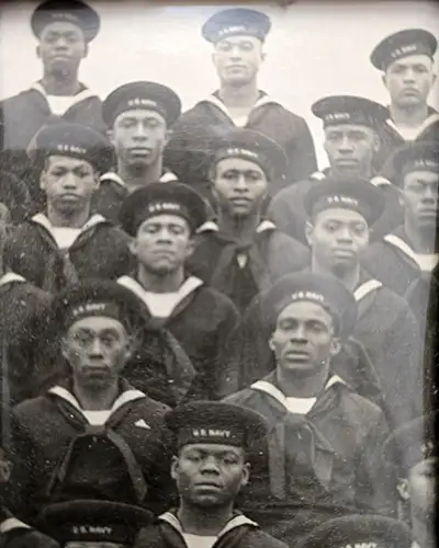 Black U.S. Navy sailors in uniform stand together in a vintage photo
