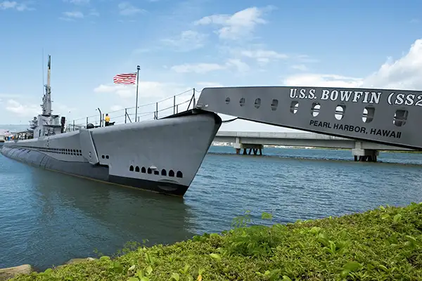 The USS Bowfin submarine sits on a shoreline