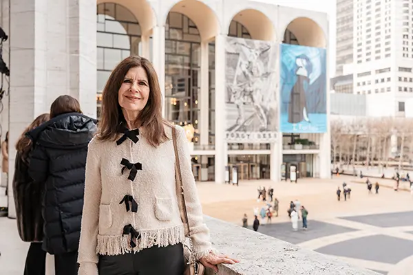 A woman stands outside the Lincoln Center for the Performing Arts in New York.
