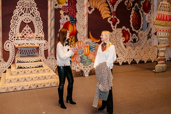 Two women stand together in front of a set from The Nutcracker.