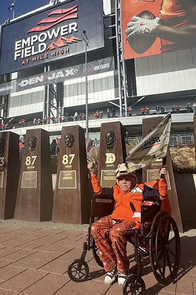 A man in a wheelchair sits outside a football stadium.