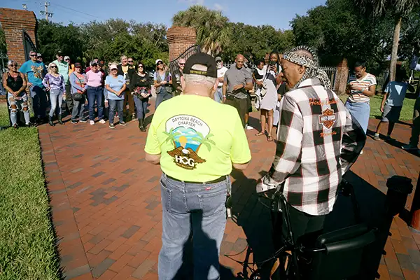 A group of Harley-Davidson motorcyclists gather together.