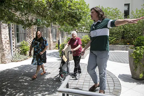 A young man leads two women on a walking tour.
