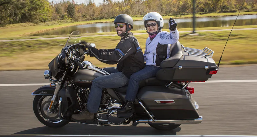 Helen-2-2 An older woman rides as a passenger on a Harley Davidson motorcycle