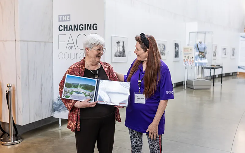 Two women stand in a museum