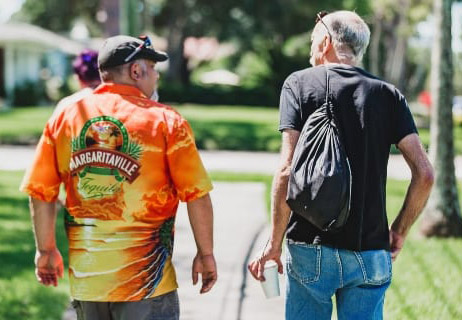 Two men converse while walking in a park