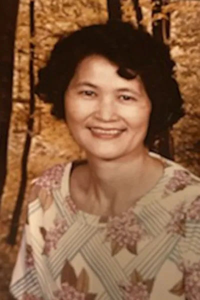 An Asian woman smiles in a vintage photograph.