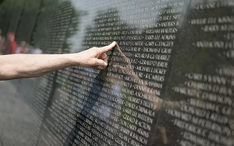 A person points out a name on the Vietnam Veterans War Memorial