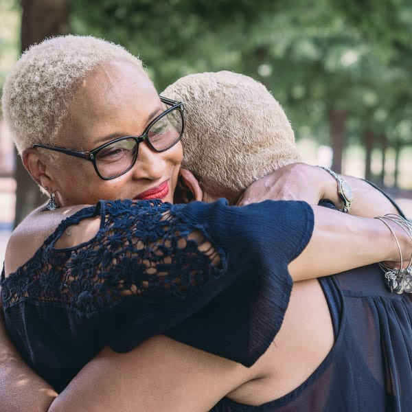 Two women embrace each other