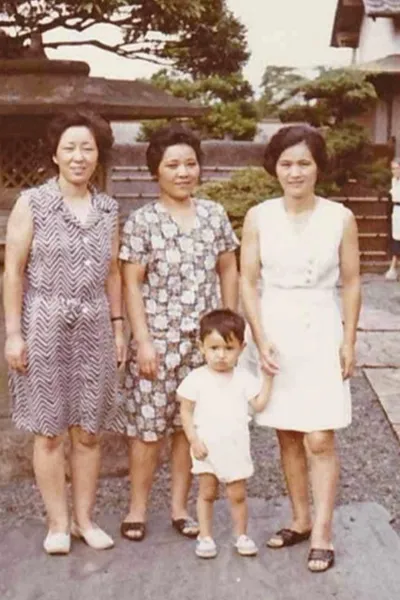 Three Japanese women stand with a toddler.