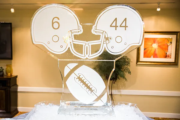 Etched glass trophy with a football and two helmets