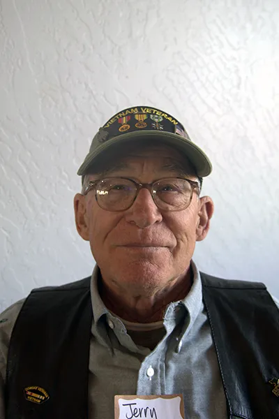 An older man wearing a Vietnam veteran ball cap.