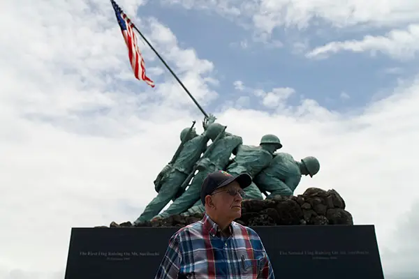 A man stands in front of a war memorial