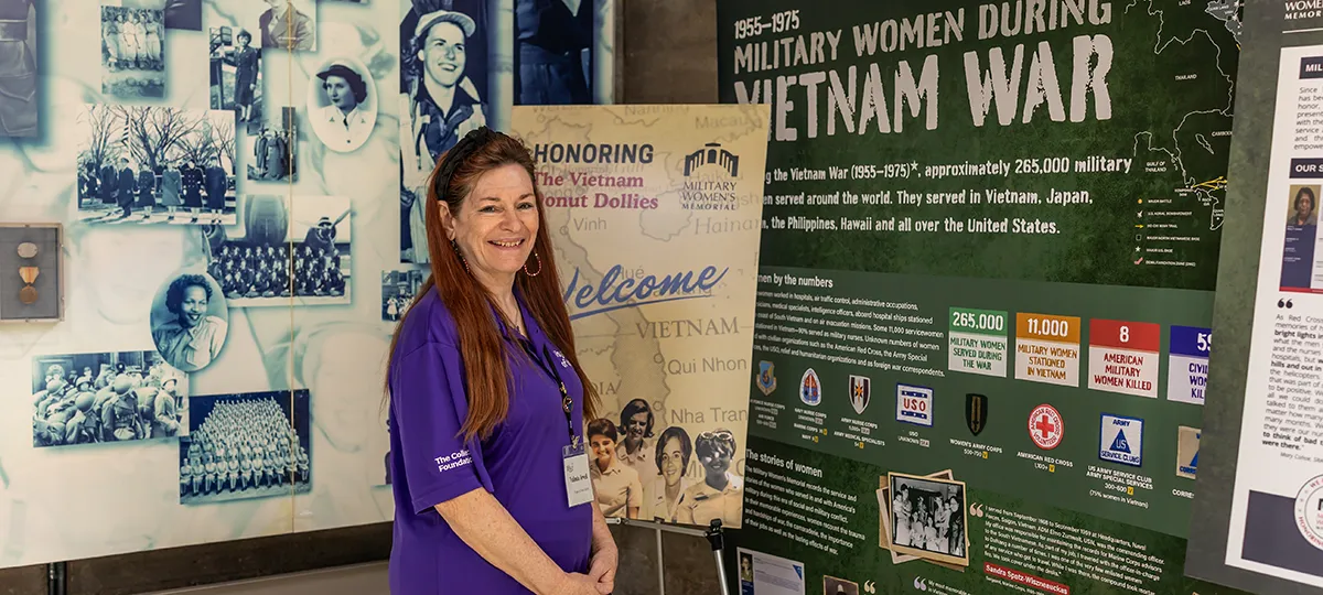 A woman stands near a museum exhibit honoring women in the Vietnam War.