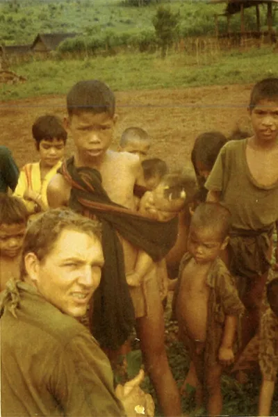 An American soldier sits next to Vietnamese children in a 1970s photo.