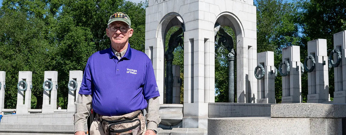A veteran stands in front of the World War II Memorial in Washington, D.C.